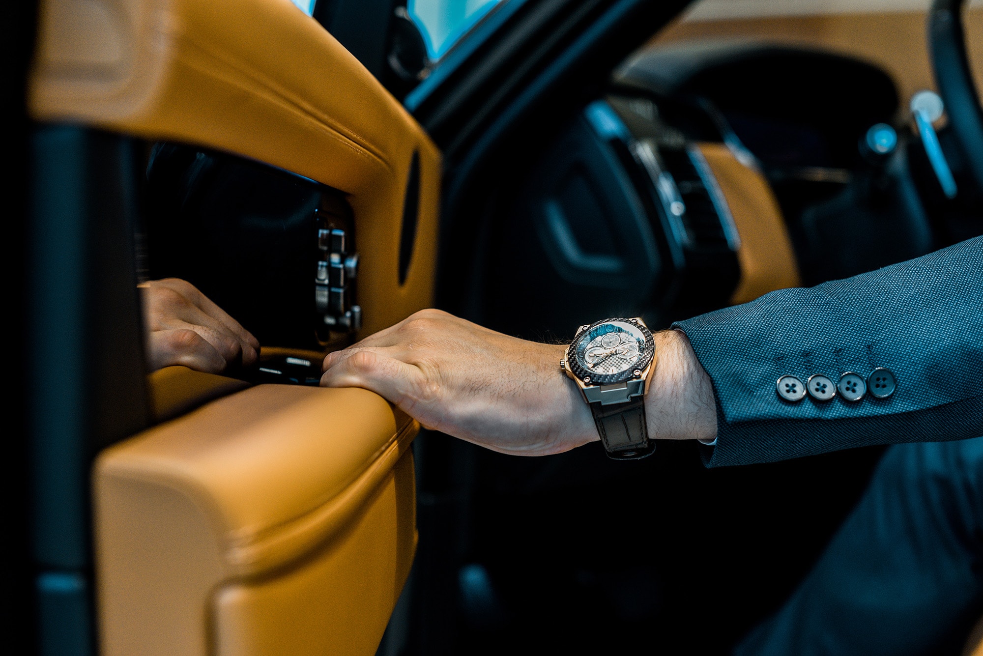 Close-up of luxury watch as businessman opens a car door